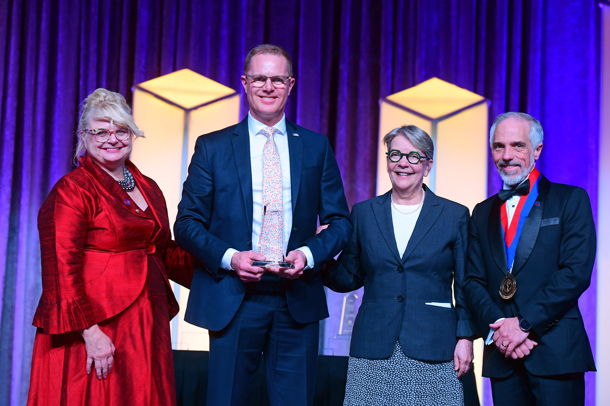 Colin Zieber holding his award with three others during the ceremony.