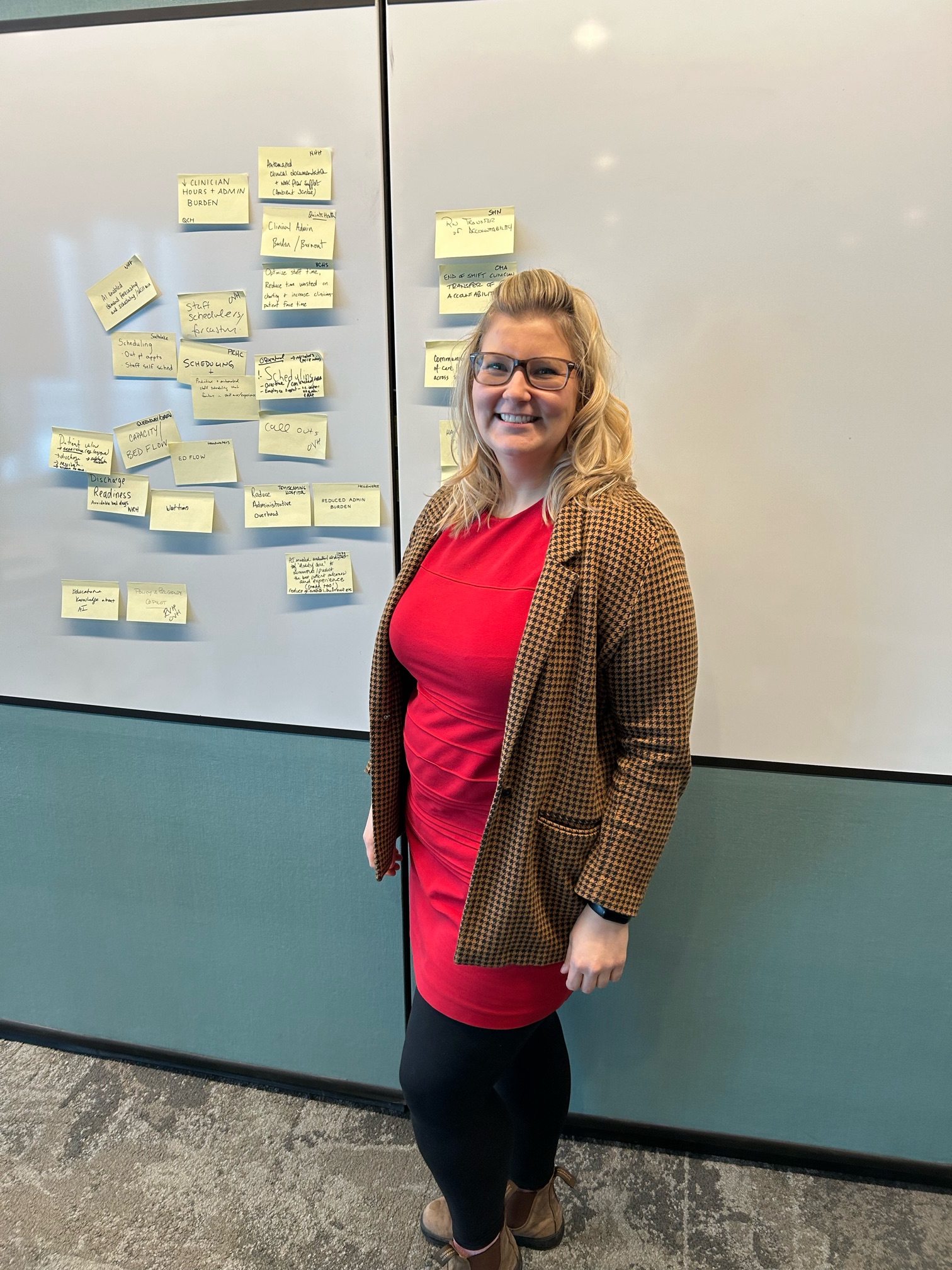 Lindsay Wyers stands, smiling, in front of a white board at the event.