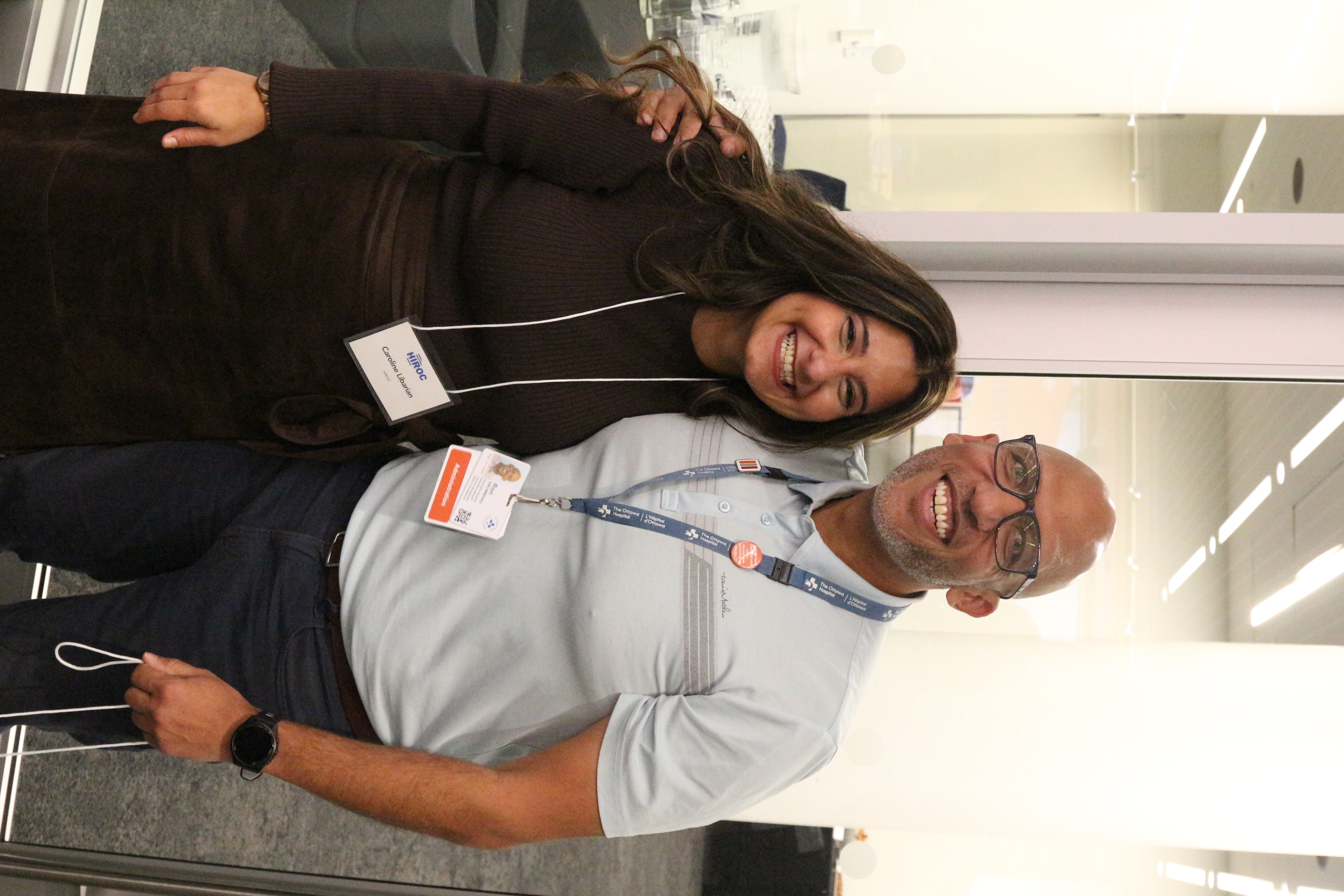 Two attendees pose and smile for the camera