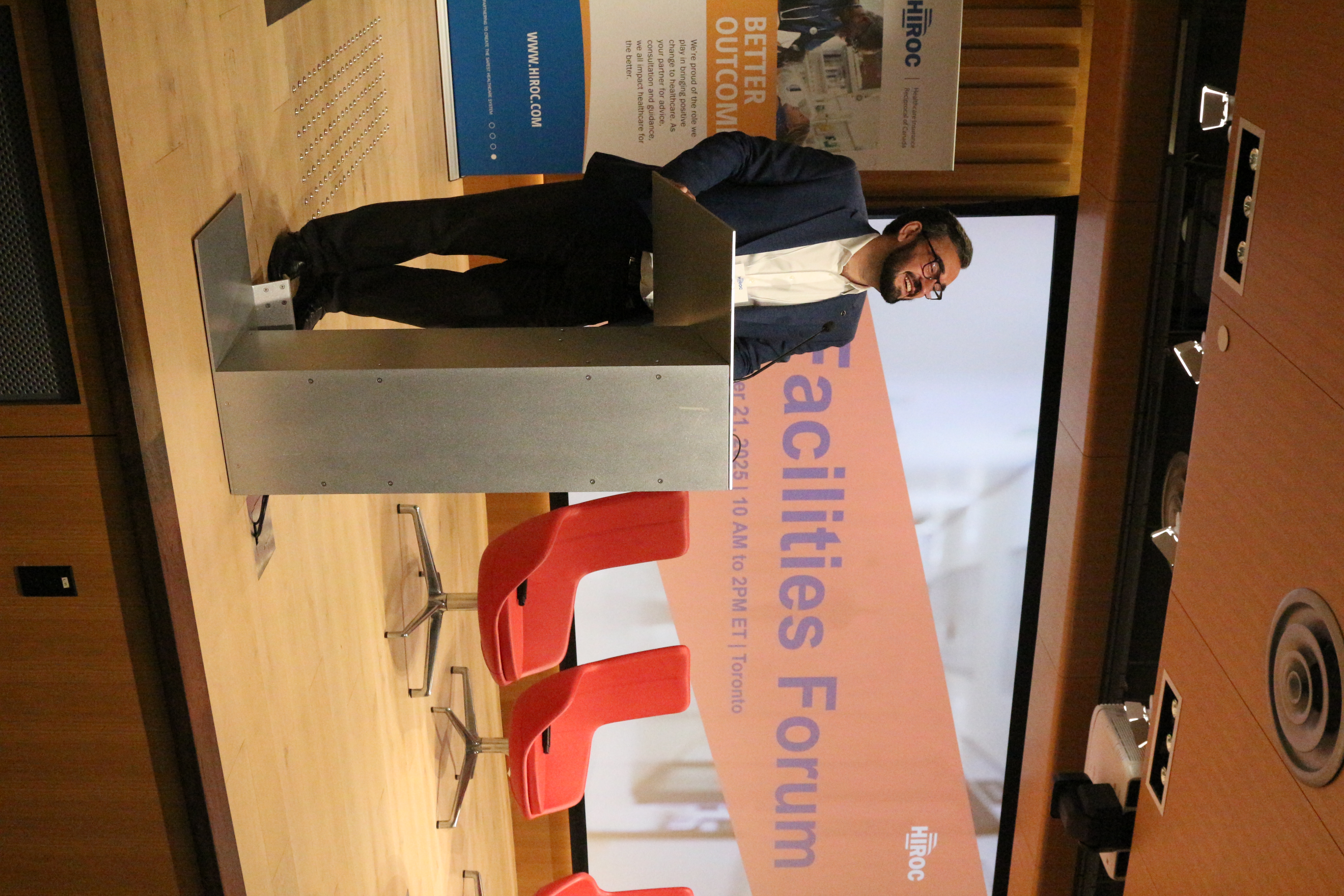 A speaker stands on stage at the podium