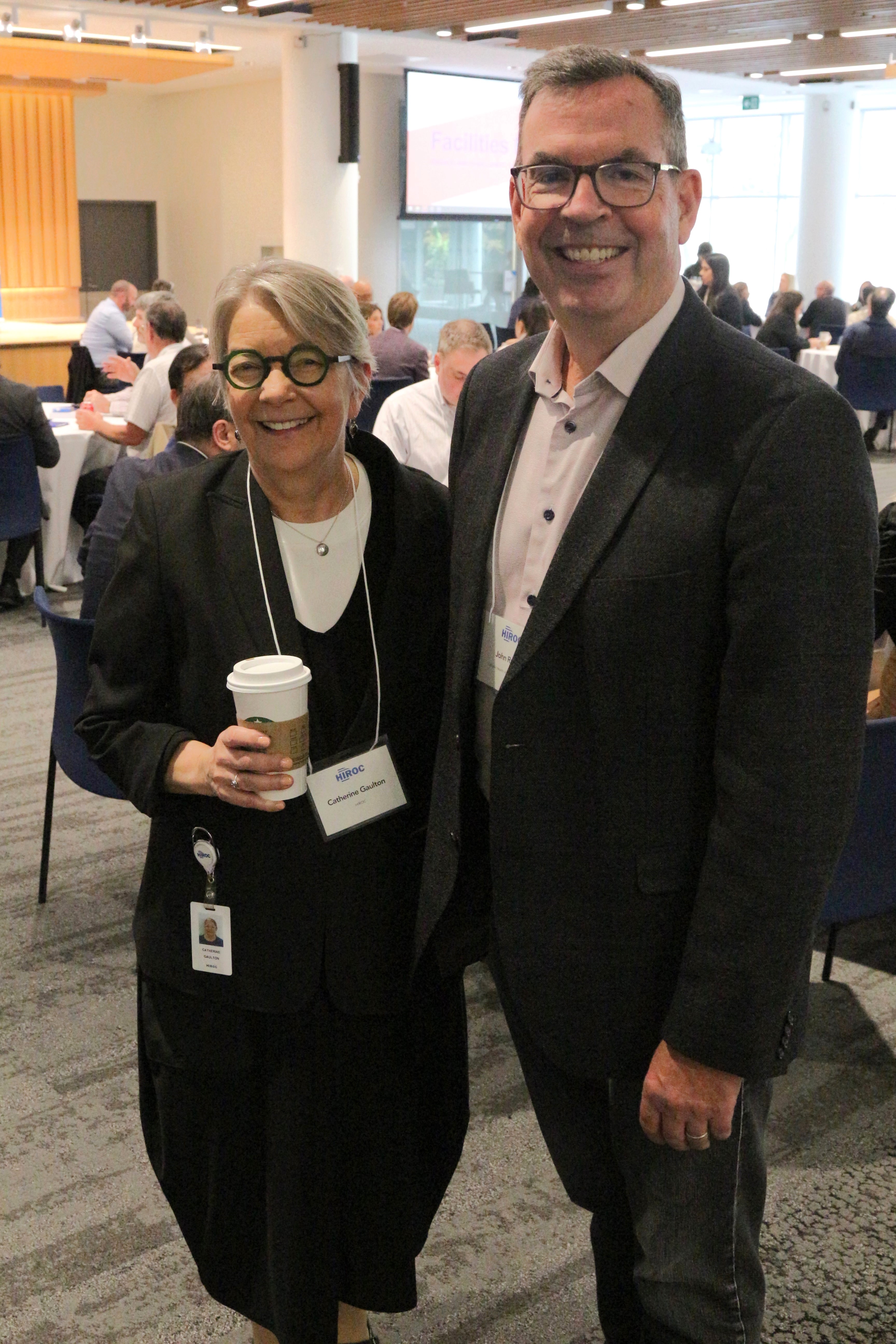 Two attendees smiling for the camera at the forum.