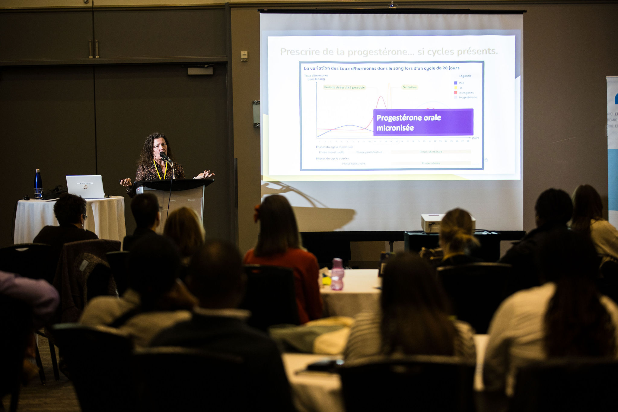 A speaker presents with a slideshow to the audience at Journées Montfort.