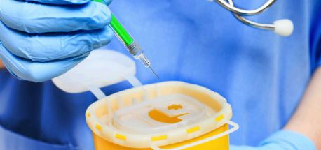 Healthcare provider placing a needle in a sharps container
