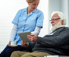 Provider sitting with patient showing tablet