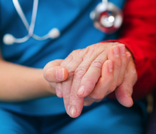 Provider holding hands with a patient or family member