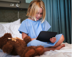 Child patient in bed with tablet