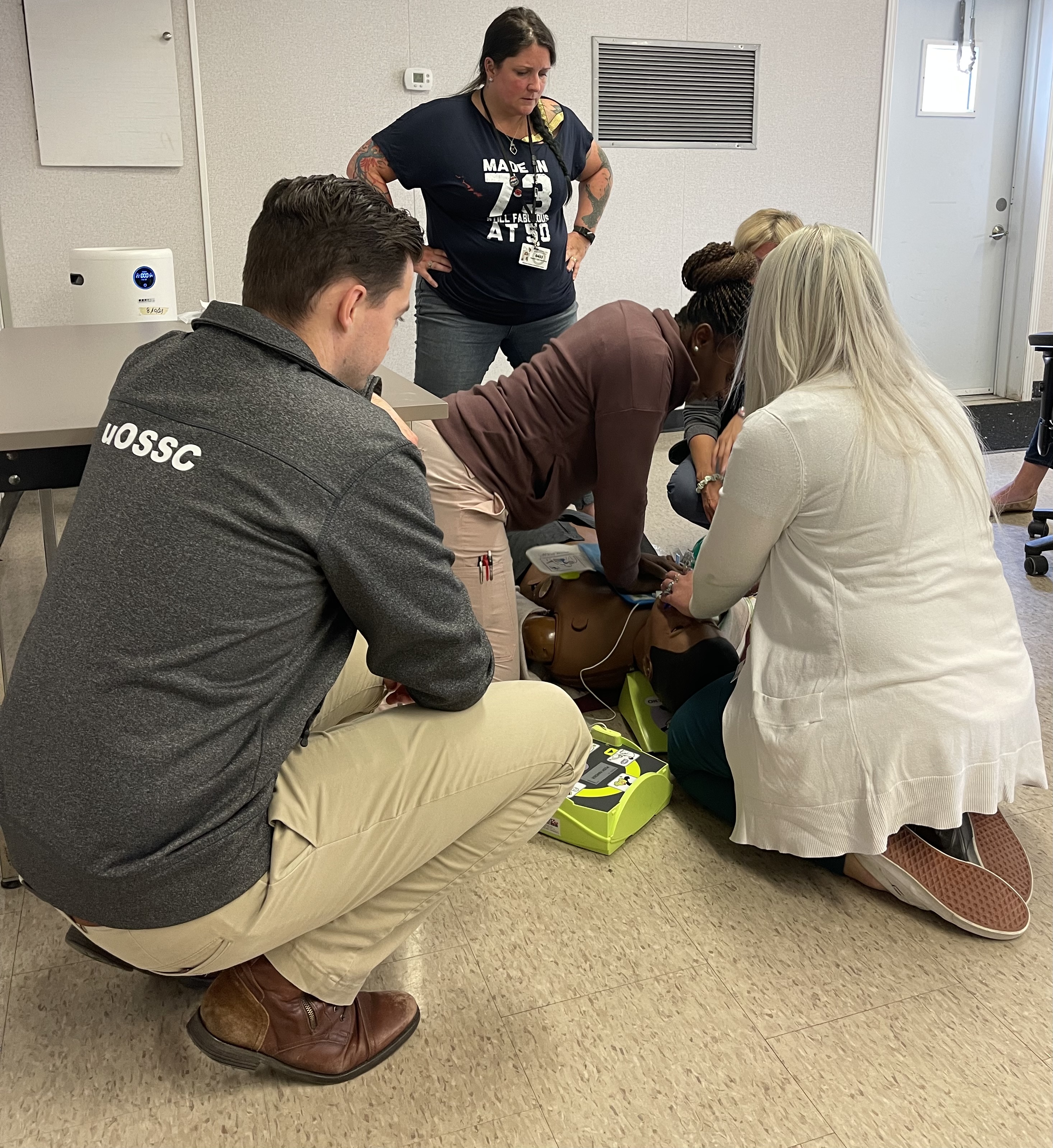 Five healthcare workers practicing CPR on a simulated patient manikin through TOH's Simulated Patient Safety Program.