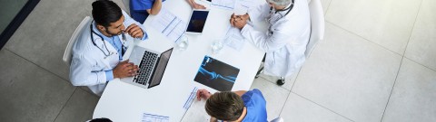 photo of medical professionals around a board table.