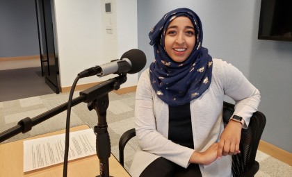 Promotional image of Huda in front of the microphone. 