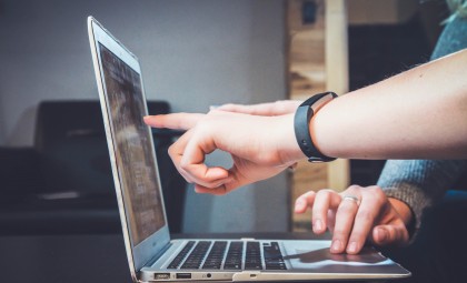 Person pointing at computer