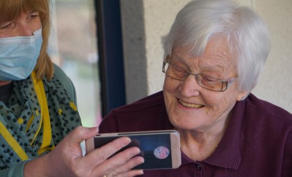 A care provider showing a phone to a patient or client