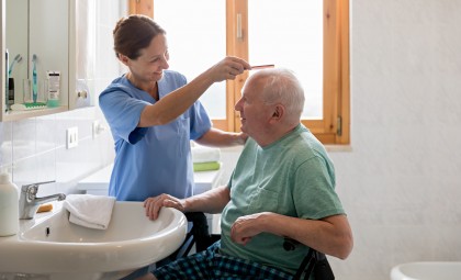 image of a healthcare provider combing a client's hair in the home