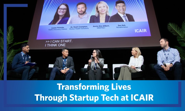 Five panel speakers sitting on stage underneath a banner introducing them with the article title at the bottom.